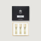 Creed Aventus perfume set with three bottles and a black box on a light gray background